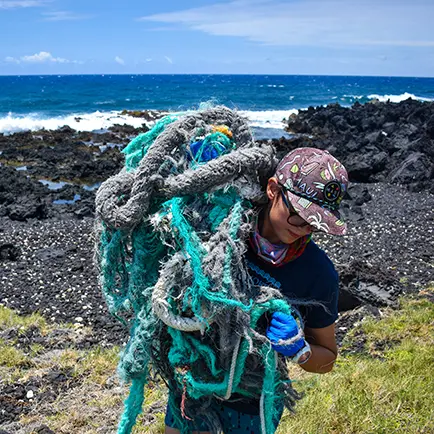 Conservationist removing marine debris from a remote shoreline